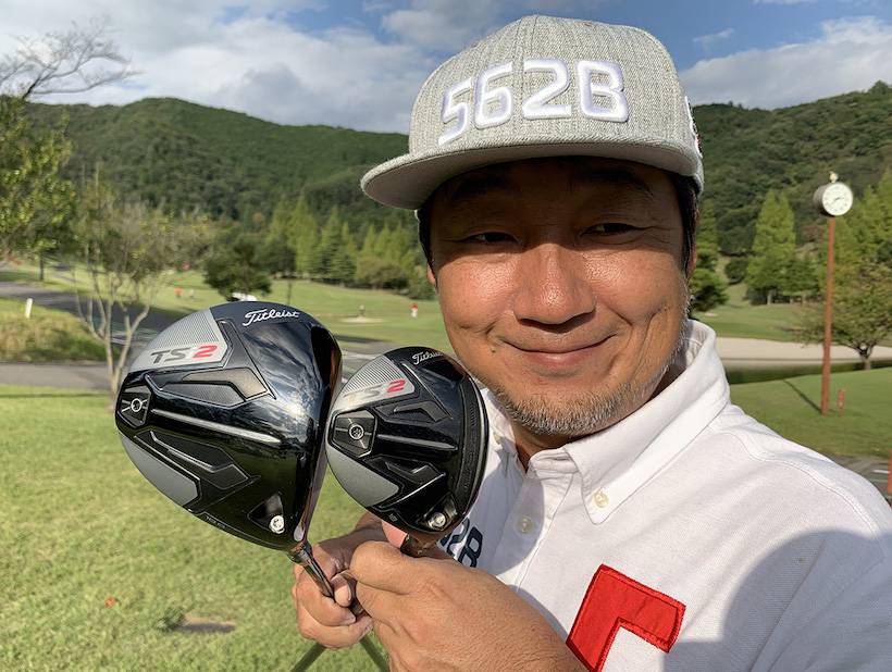 野村タケオがクラブを2本持って立っている写真
